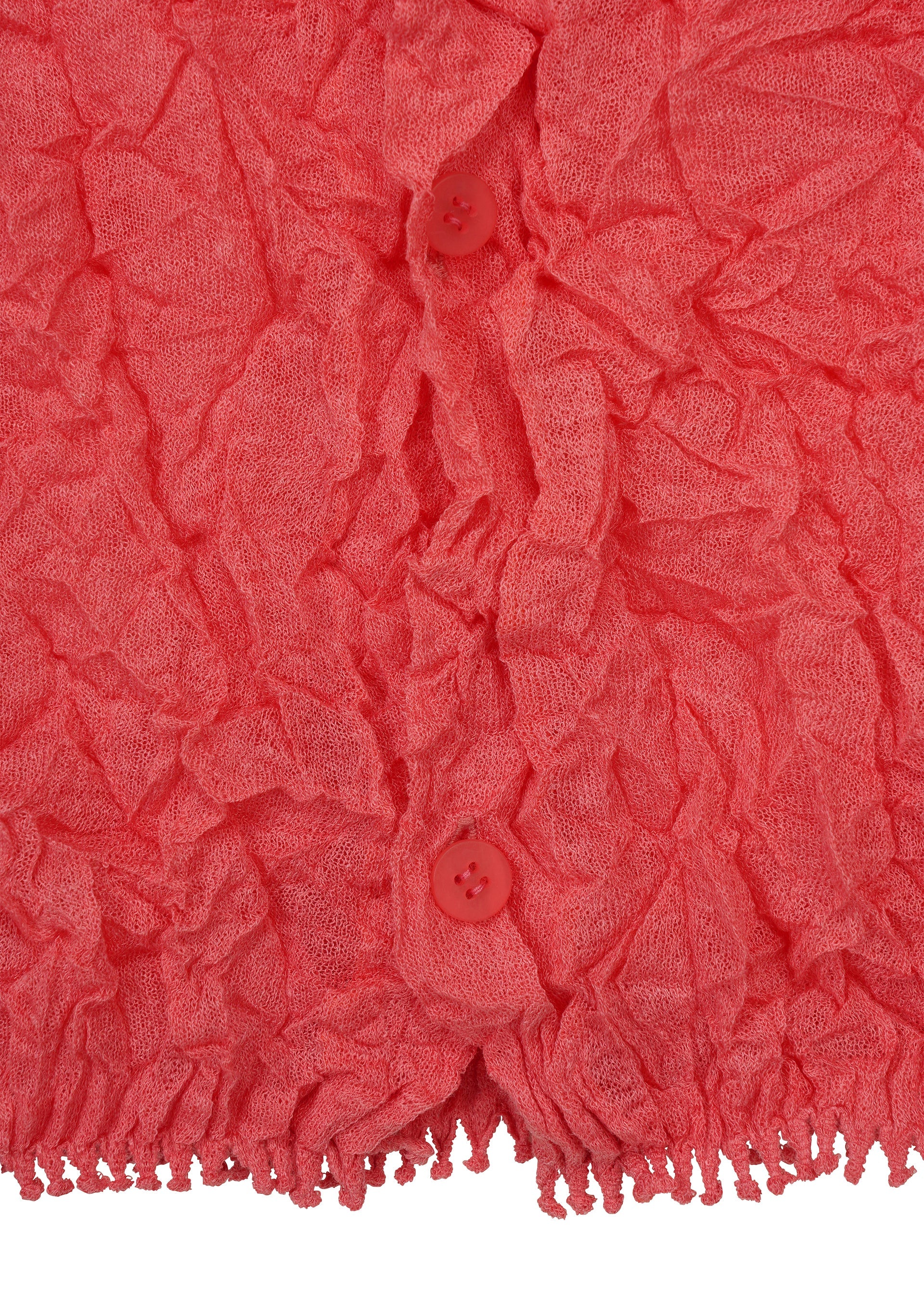 Zoomed view Close-up of a textured, crinkled pink KUMO SHIBORI KNIT SHEER by HaaT, featuring two matching pink buttons and a fringe detail at the bottom edge.