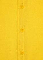 Close-up of a yellow minimalist knit fabric from the AIRY POCKET LAYERS collection by HaaT, featuring three yellow buttons sewn down the center—likely part of a long-sleeved cardigan. The texture of the polyester wool blend is visible.