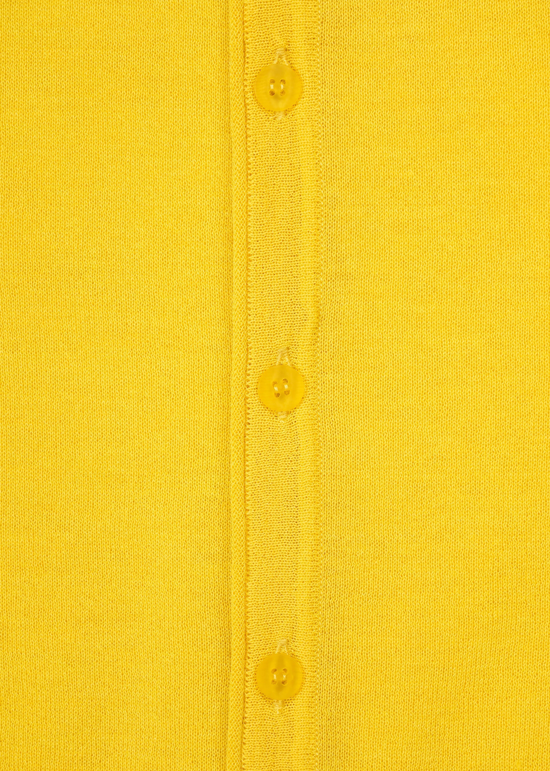Zoomed view Close-up of a yellow minimalist knit fabric from the AIRY POCKET LAYERS collection by HaaT, featuring three yellow buttons sewn down the center—likely part of a long-sleeved cardigan. The texture of the polyester wool blend is visible.