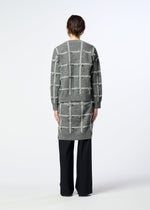 A person stands facing away, wearing the HaaT RIBBON KNIT long-sleeved cardigan with a grid pattern over black pants, against a plain light background.