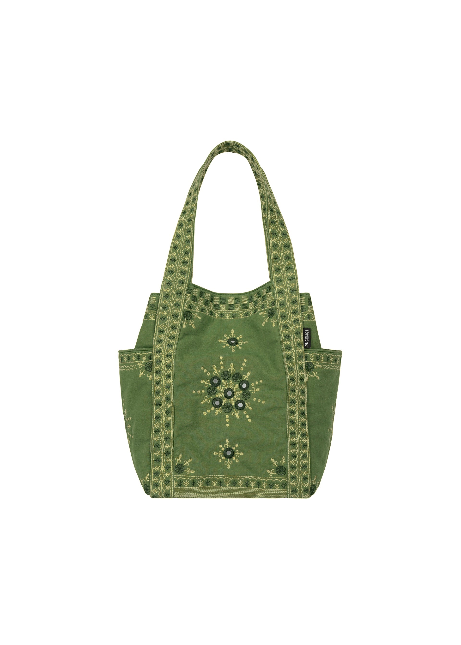 Zoomed view Sure! Here is the rewritten sentence using the provided product data: The DAZZLE MIRROR BOX by HaaT is a green mini tote bag with two handles, featuring an exquisitely embroidered floral pattern and decorative border details inspired by Bhill embroidery. Handcrafted by Indian artisans, this bag offers convenient side pockets and a central embroidered design in yellow and black on a white background.