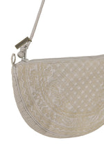 Introducing the BLOOM & PLAID BOSTON by HaaT—a cream-colored, half-moon crossbody bag featuring intricate Bhill embroidery, a zipper closure, and a slim strap adorned with a small metal tag. Expertly crafted in India, this elegant pouch blends timeless style with artisanal craftsmanship.