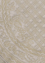Close-up of beige quilted fabric with intricate floral and lattice embroidery, creating a textured and decorative surface. The BLOOM & PLAID BOSTON pouch by HaaT showcases exquisite Bhill embroidery, highlighting artisanal craftsmanship made in India.