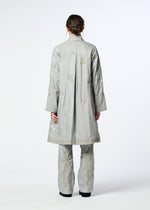 A person stands facing away, wearing HaaT’s DELICATE FLORAL BHILL light gray, knee-length evening coat and matching pants with subtle Bhill embroidery. Hair is tied back; background is plain white.