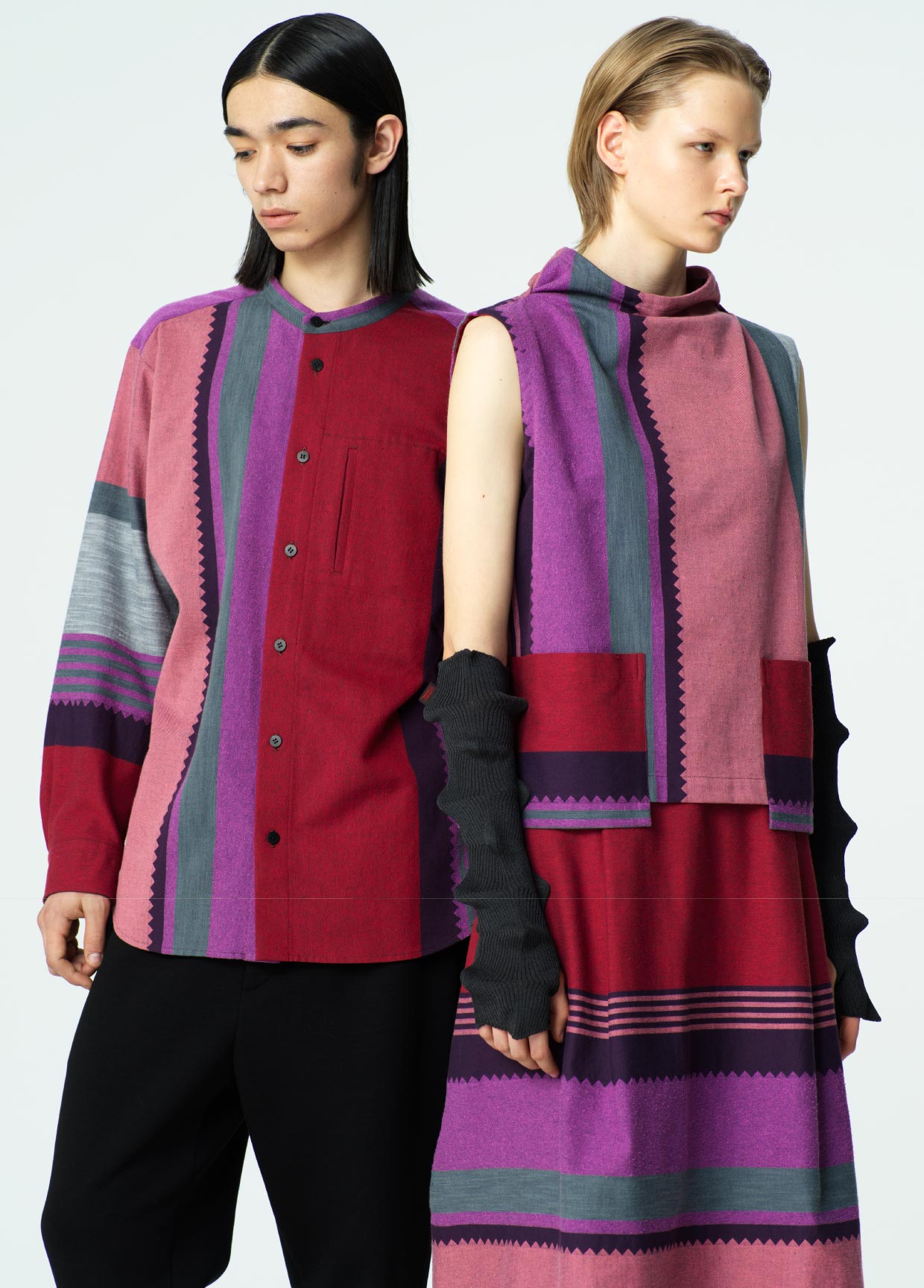 Two models wearing colorful patterned outfits on a plain background