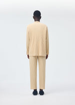 A person stands facing away, wearing the HOMME PLISSÉ ISSEY MIYAKE TAILORED PLEATS 2 beige pleated long-sleeve top and pants set, made from quick-drying polyester with black shoes, against a plain white background.