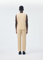 A person stands facing away from the camera, wearing the beige TAILORED PLEATS 2 set by HOMME PLISSÉ ISSEY MIYAKE—featuring a pleated round-neck vest and matching quick-dry polyester pants—with black shoes.