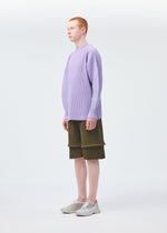 A person with short red hair stands sideways, wearing a long-sleeved, light purple ribbed top, HOMME PLISSÉ ISSEY MIYAKE PLEATS BOTTOMS 2 in olive green, and light gray sneakers against a plain white background.