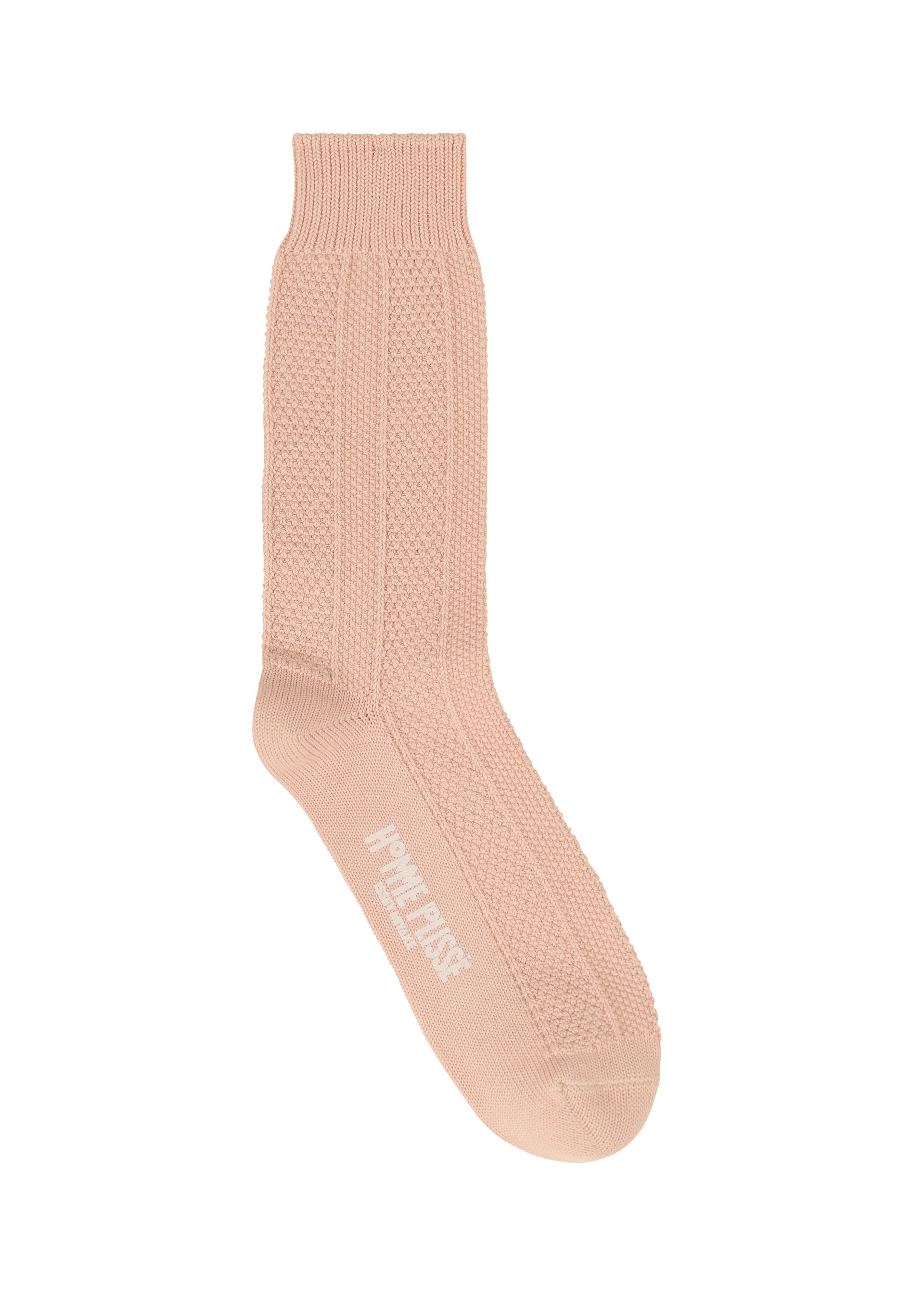 Zoomed view A single STEM SOCK by HOMME PLISSÉ ISSEY MIYAKE in light beige knit with a ribbed cuff and white logo text on the sole, shown against a plain white background.