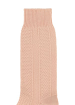 A close-up of a light pink STEM SOCK by HOMME PLISSÉ ISSEY MIYAKE, featuring a textured ribbed and patterned knit—ideal for those who appreciate stylish, designer socks.