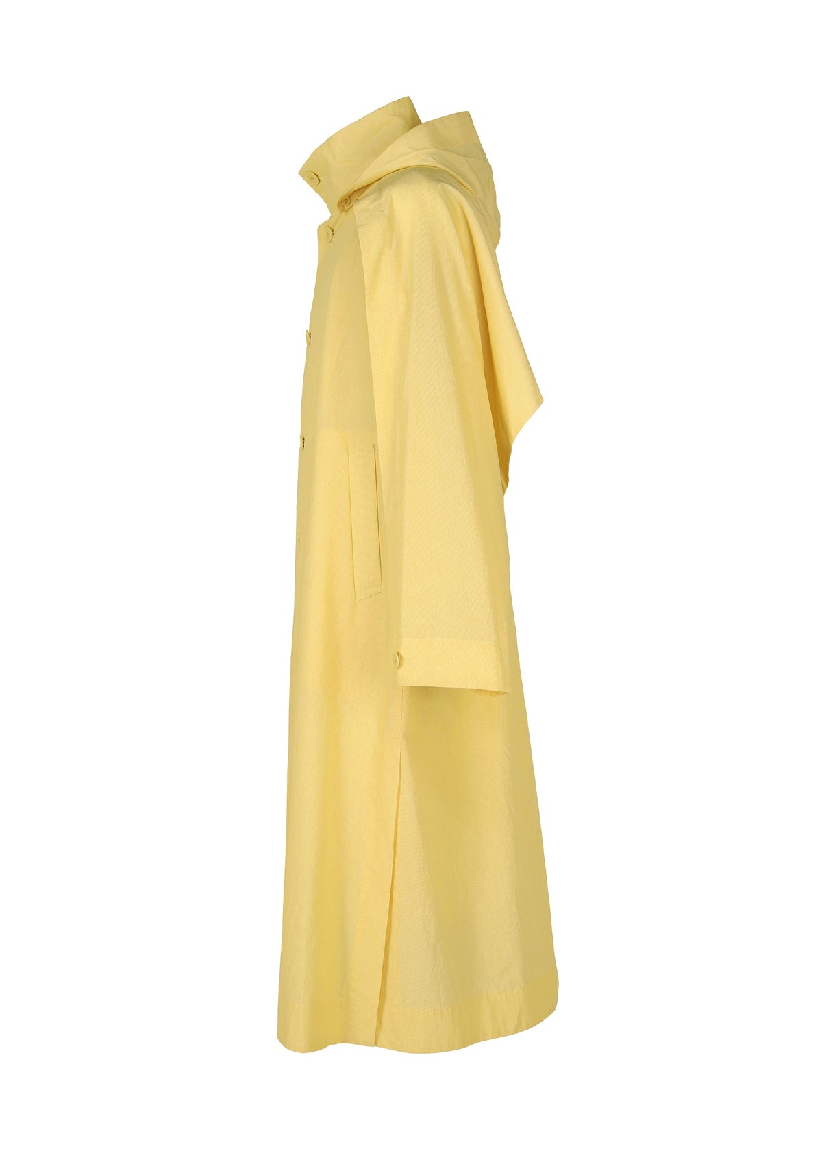 Side view of the FRESHEN coat by HOMME PLISSÉ ISSEY MIYAKE: a long, light yellow hooded piece with front pockets, buttons, straight cut, three-quarter sleeves, and a stylish subtle wrinkled texture. view 5 of 9