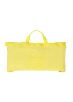 The CARRIER CARRIED by HOMME PLISSÉ ISSEY MIYAKE is a rectangular yellow water-repellent polyester bag with two short handles and a matching front logo—perfect for carrying a packable jacket or using as a travel garment bag.