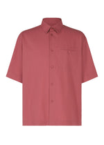 The PL RAMIE SHIRT by HOMME PLISSÉ ISSEY MIYAKE is a muted red, short-sleeved linen-blend shirt featuring a classic collar, left chest pocket, button-up front, and a breathable, comfortable fit in a simple design. - WINE RED （no.29）