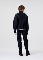 Facing away, a person with wavy hair wears the HOMME PLISSÉ ISSEY MIYAKE MULTI-FASTENED dark pinstriped suit and matching pants, styled with dark shoes and an adjustable zipper jacket against a plain light background.
