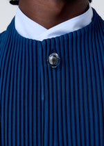 Close-up of a person wearing the HOMME PLISSÉ ISSEY MIYAKE TAILORED PLEATS 1—a deep blue, quick-drying polyester piece with pleats, a white collar, and round clear neckline button. Only the lower face and upper chest are visible. Versatile for any occasion.