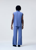 A person with medium-dark skin and shoulder-length dreadlocks faces away, wearing HOMME PLISSÉ ISSEY MIYAKE TAILORED PLEATS 1—a quick-drying light blue sleeveless top and matching wide-leg pants—against a plain light background.