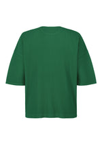 The "MONTHLY COLORS : MAY" top by HOMME PLISSÉ ISSEY MIYAKE is a green, round-neck, short-sleeved polyester with a boxy fit and vertical ribbed texture, shown from the back on a plain white background.