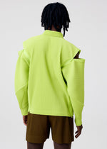 A person with short dreadlocks is seen from the back wearing the HOMME PLISSÉ ISSEY MIYAKE MULTI-FASTENED yellow-green textured jacket with cutout shoulders and brown pleated shorts, set against a plain light background.