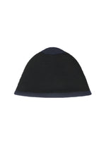 The WINTER GEAR : COLOR BLOCK by HOMME PLISSÉ ISSEY MIYAKE is a black knitted beanie with a rounded shape and a thick bottom band, shown on a white background.