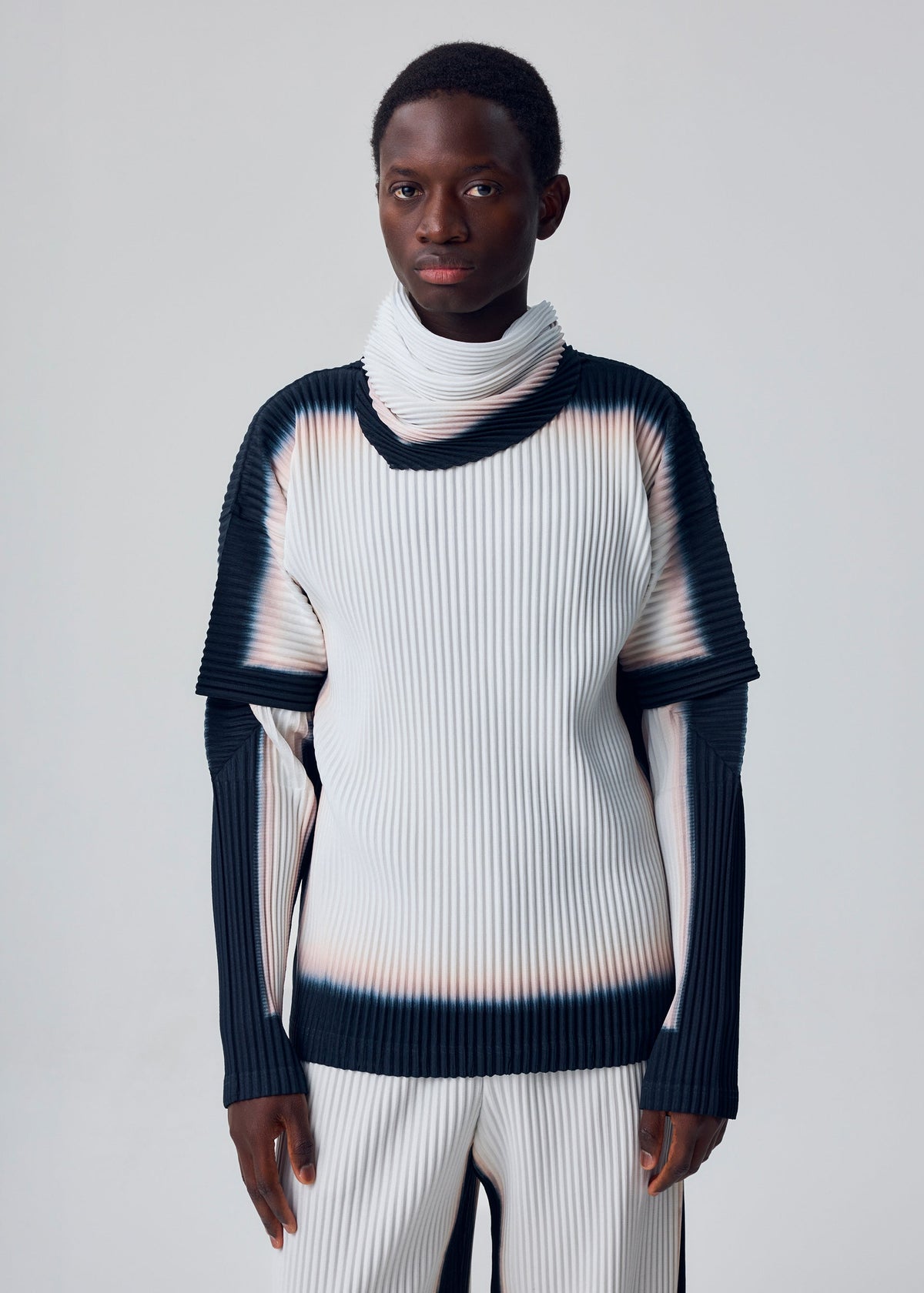 A person stands against a plain background, wearing the FRAMEWORK : CHUSEN STOLE by HOMME PLISSÉ ISSEY MIYAKE, and looks directly at the camera with a neutral expression. view 4 of 4