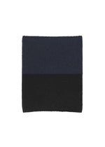 The WINTER GEAR : COLOR BLOCK by HOMME PLISSÉ ISSEY MIYAKE is a square, knitted neck warmer featuring dark blue on top and black on the bottom, shown on a white background. - NAVY （no.75）