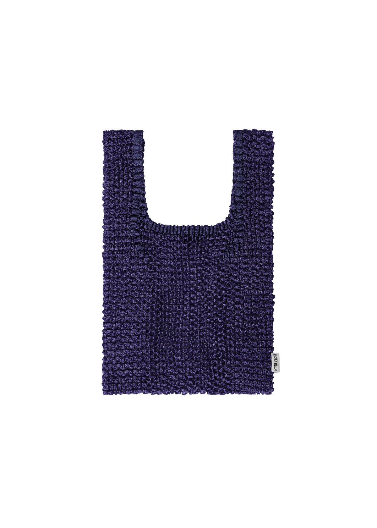 The MESH PLEATS BAG by HOMME PLISSÉ ISSEY MIYAKE is a deep purple, rectangular tote with short handles and a textured knit design that highlights minimalist craftsmanship. Detailed with a small white tag on the lower right side, the bag is presented against a white background. view 3 of 7