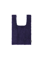 The MESH PLEATS BAG by HOMME PLISSÉ ISSEY MIYAKE is a deep purple, rectangular tote with short handles and a textured knit design that highlights minimalist craftsmanship. Detailed with a small white tag on the lower right side, the bag is presented against a white background. - BLUE （no.72）