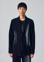 A person with short black hair wears the IN THE SHADOW set by HOMME PLISSÉ ISSEY MIYAKE—loose-fitting, optical-illusion stripe jacket and pants—against a plain light gray background.