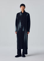 A person with short hair and a neutral expression wears the IN THE SHADOW jacket by HOMME PLISSÉ ISSEY MIYAKE over matching pinstriped pants and black shoes, standing against a plain background. The jacket is loose and buttoned up front.