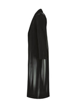 IN THE SHADOW by HOMME PLISSÉ ISSEY MIYAKE: a long black designer coat with a notched collar, three-quarter sleeves, and light vertical streaks for an optical-illusion stripe effect. Shown from the side.