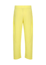 The SLASH pants by HOMME PLISSÉ ISSEY MIYAKE are yellow, full-length pants featuring diagonal pleats, an elastic waistband, and a relaxed fit, shown against a white background.