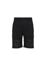 The LACE GRID PLEATS shorts by HOMME PLISSÉ ISSEY MIYAKE feature a black textured design with a subtle grid pattern, crafted from a cotton-blend polyester and finished with an elastic waistband. These knee-length shorts are shown against a plain white background. - BLACK （no.15）