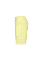 The LACE GRID PLEATS skirt by HOMME PLISSÉ ISSEY MIYAKE, a knee-length design in light yellow with a grid-textured pattern crafted from cotton-blend polyester, is displayed in a side view against a plain white background.
