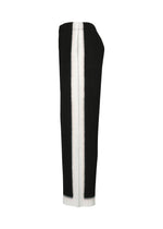 FRAMEWORK : CHUSEN by HOMME PLISSÉ ISSEY MIYAKE—pleated straight pants with black and white color block stripes inspired by chusen, featuring black sides and a white center, shown from the side.