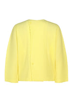 The “SLASH” jacket by HOMME PLISSÉ ISSEY MIYAKE is a light yellow, long-sleeve piece featuring an asymmetrical front with two visible buttons. Its fabric showcases distinctive diagonal pleats and a textured, diagonal line pattern, offering a modern reinterpretation of the classic cardigan.