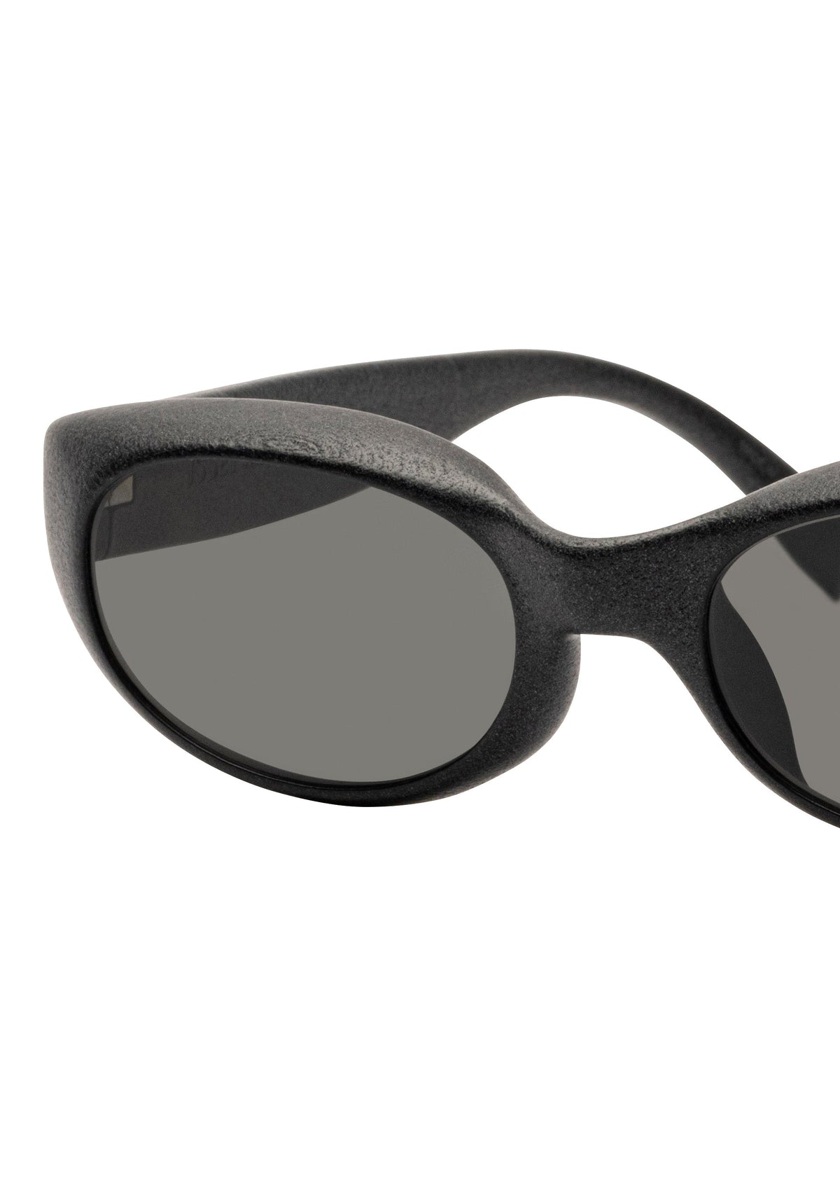 Close-up of the left side of ISSEY MIYAKE EYES GRIT-SQUARE black 3D printed sunglasses with dark oval lenses, shown against a white background. view 3 of 7