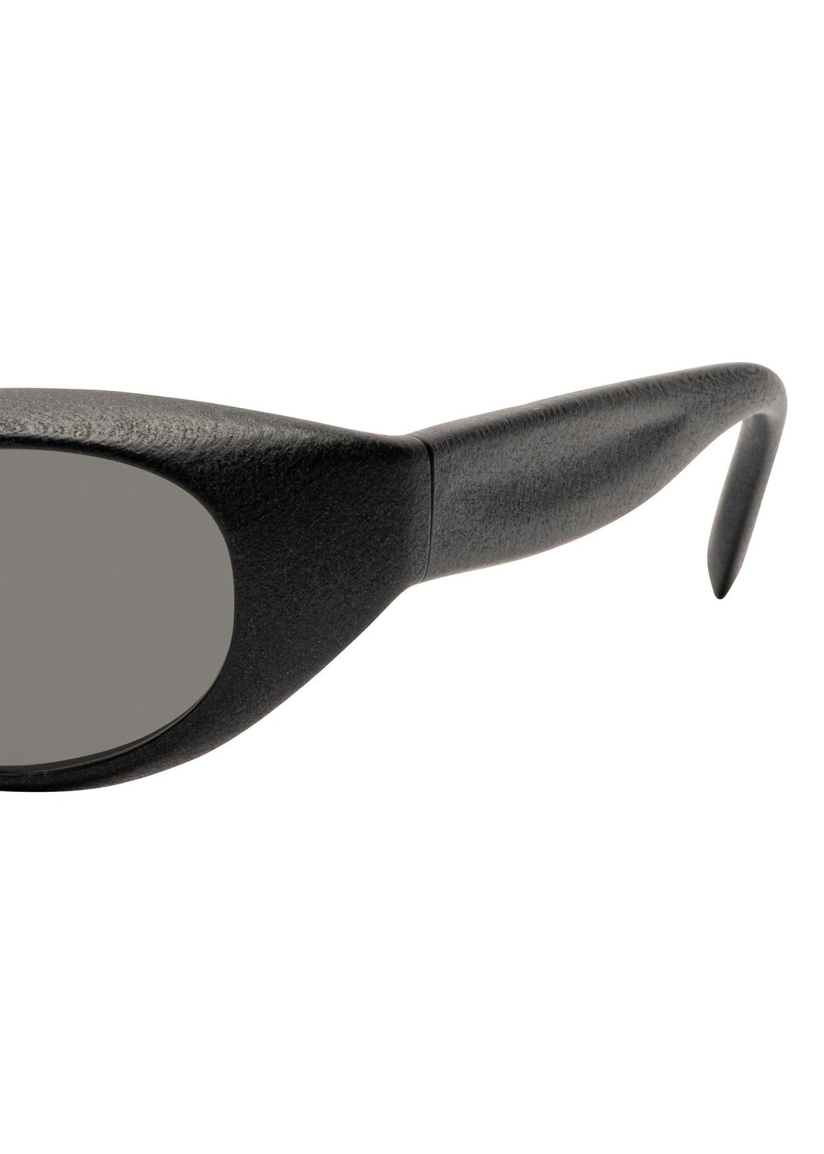 Close-up of the left side of ISSEY MIYAKE EYES GRIT-SQUARE black square sunglasses, highlighting the thick textured arm and the edge of a dark lens set against a white background. view 4 of 7