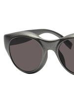 Close-up of the left half of ISSEY MIYAKE EYES GRIT-BOSTON sunglasses in matte black with dark lenses, set against a white background.