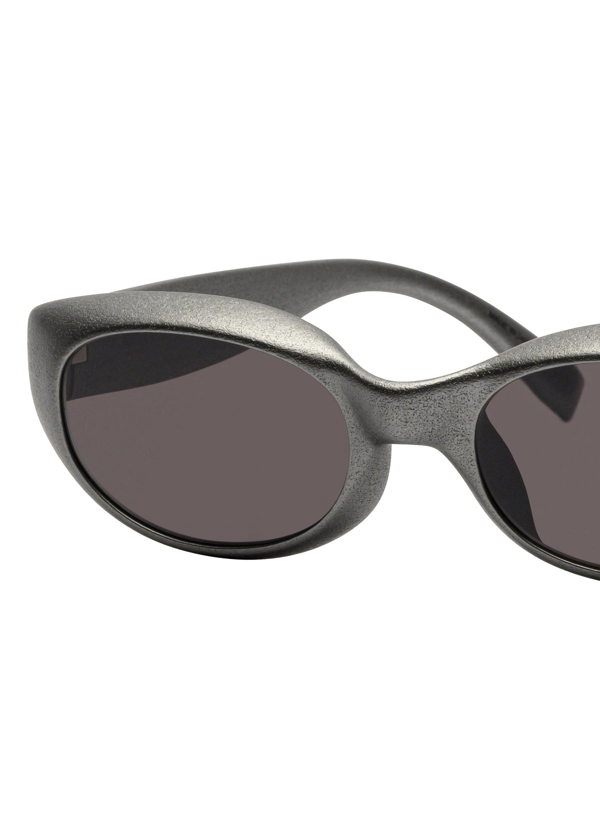 Close-up of ISSEY MIYAKE EYES GRIT-SQUARE sunglasses: silver, oval-shaped 3D printed design with dark tinted lenses, a thick textured frame, and curved arms against a white background. view 3 of 5