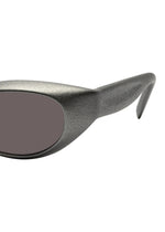 Close-up of the side of ISSEY MIYAKE EYES GRIT-SQUARE 3D printed sunglasses, featuring a textured metallic gray frame, dark oval lenses, and a thick arm.