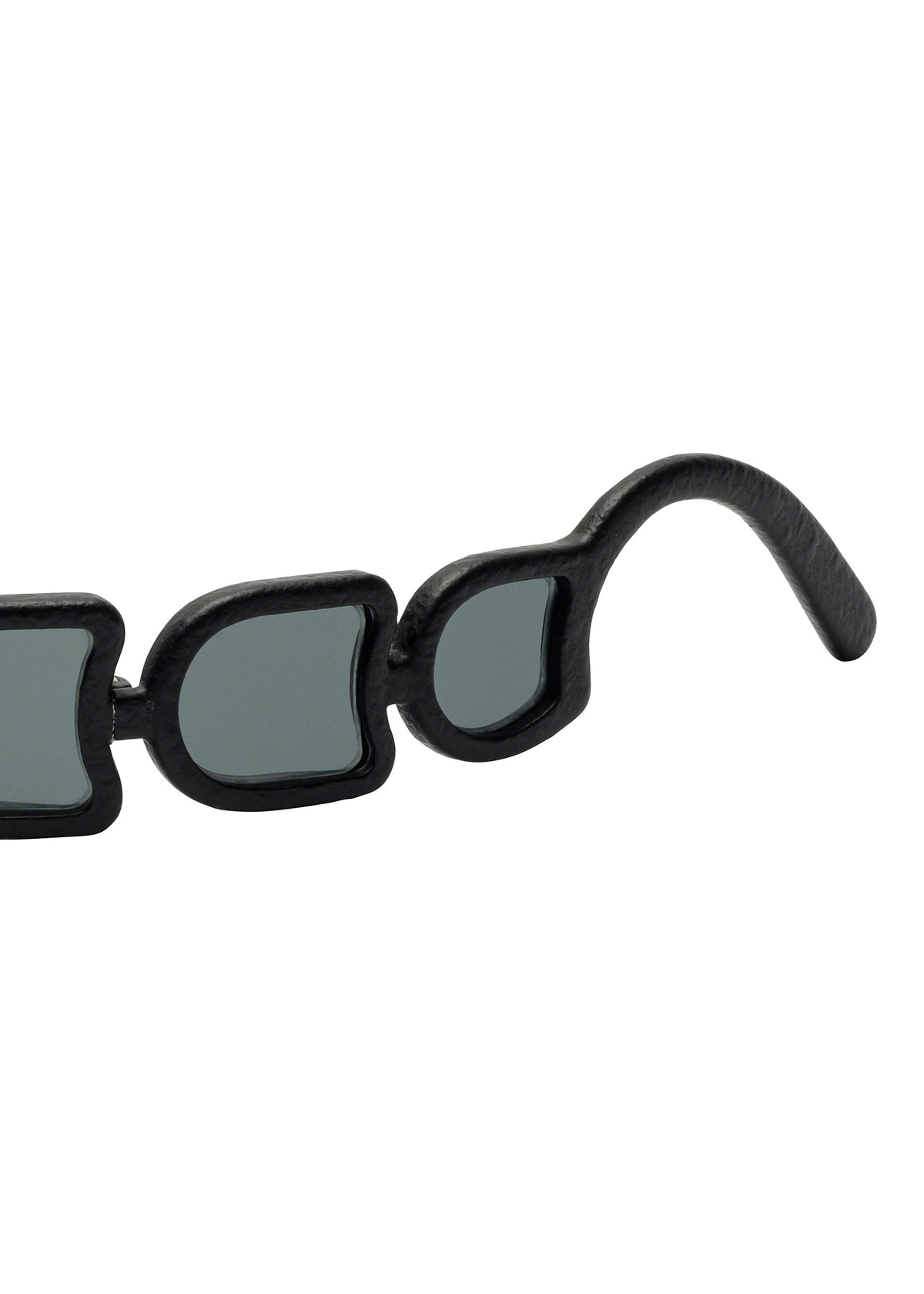 Close-up of the black temple and rim of ISSEY MIYAKE EYES UROKO sunglasses, showcasing uniquely irregular lenses and frames crafted with Japanese craftsmanship against a white background. view 4 of 5