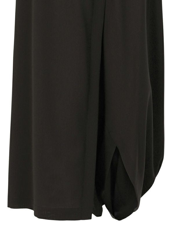 A close-up of SEAMLESS BOTTOMS by 132 5. ISSEY MIYAKE in black recycled polyester highlights their draped, layered design and rounded hem, creating a relaxed, skirt-like silhouette. view 7 of 11