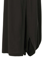 A close-up of SEAMLESS BOTTOMS by 132 5. ISSEY MIYAKE in black recycled polyester highlights their draped, layered design and rounded hem, creating a relaxed, skirt-like silhouette.
