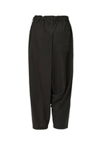 SEAMLESS BOTTOMS by 132 5. ISSEY MIYAKE are loose-fitting black sarouel pants with an elastic waist, cropped legs, and a right pocket. Made from soft recycled polyester, they feature a relaxed silhouette and gentle draping for casual style.