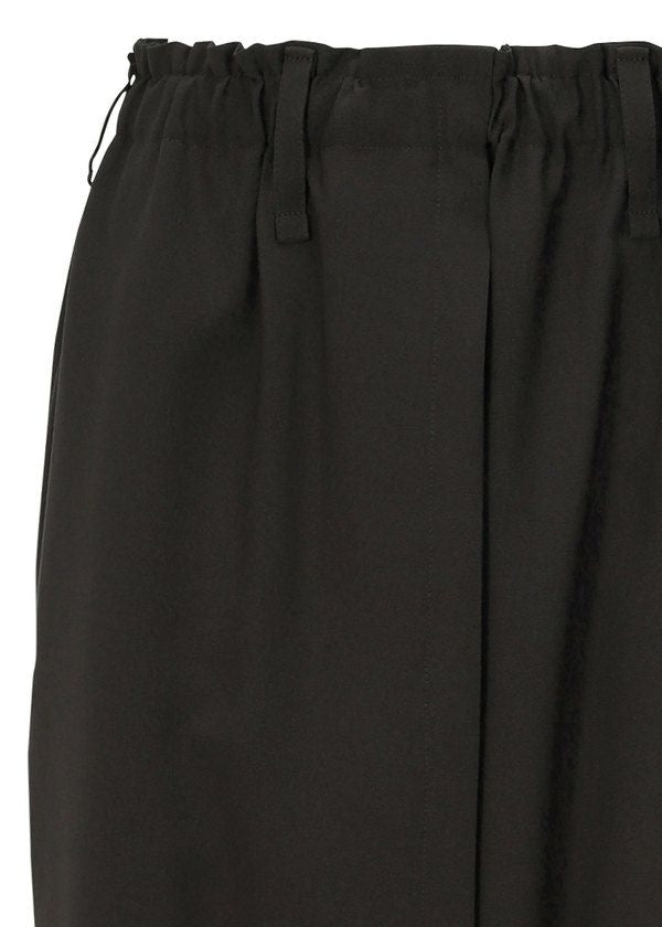 Close-up of SEAMLESS BOTTOMS by 132 5. ISSEY MIYAKE—black skirt with an elastic waistband and belt loops, made from recycled polyester. Its textured fabric and pleats offer a relaxed silhouette inspired by sarouel pants. view 5 of 12