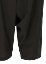 Close-up of the lower part of SEAMLESS BOTTOMS by 132 5. ISSEY MIYAKE, showing the relaxed silhouette and how the recycled polyester drapes near the knees.