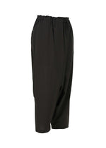 SEAMLESS BOTTOMS by 132 5. ISSEY MIYAKE are black sarouel pants with a relaxed, draped silhouette and elastic waistband, crafted from recycled polyester and shown on a white background.