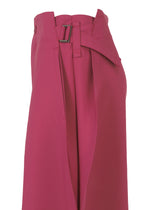 A close-up of the VERTEX BOTTOMS by 132 5. ISSEY MIYAKE—high-waisted, wide-leg magenta pants with a folding structure, pleated front, and an overlapping belt finished with a rectangular metal buckle.