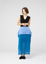 A woman with a short bob wears the SHEER FOLIO layered petticoat skirt by 132 5. ISSEY MIYAKE, paired with a sleeveless black top and black shoes, standing against a plain light gray background.