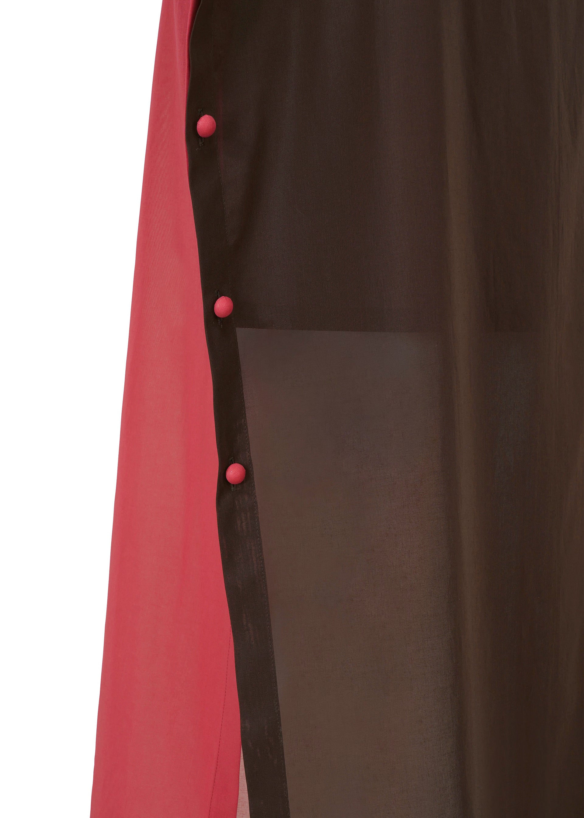 Zoomed view Close-up of the SHEER FOLIO by 132 5. ISSEY MIYAKE, showing a sheer black panel over solid pink fabric, layered like a skirt and secured with four round pink buttons along the seam.